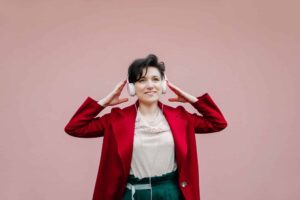 headphones earphones listening music gen z playlist woman girl female happy young pink wall t20 7y7JON