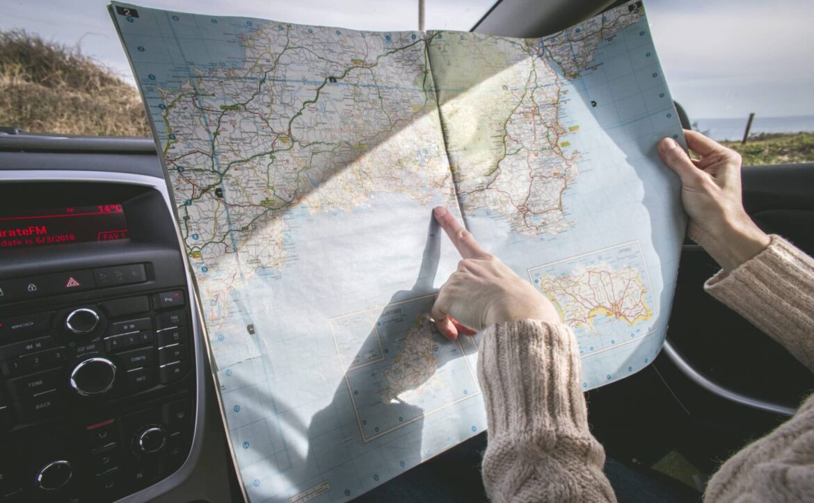 person wearing beige sweater holding map inside vehicle stockpack pexels scaled