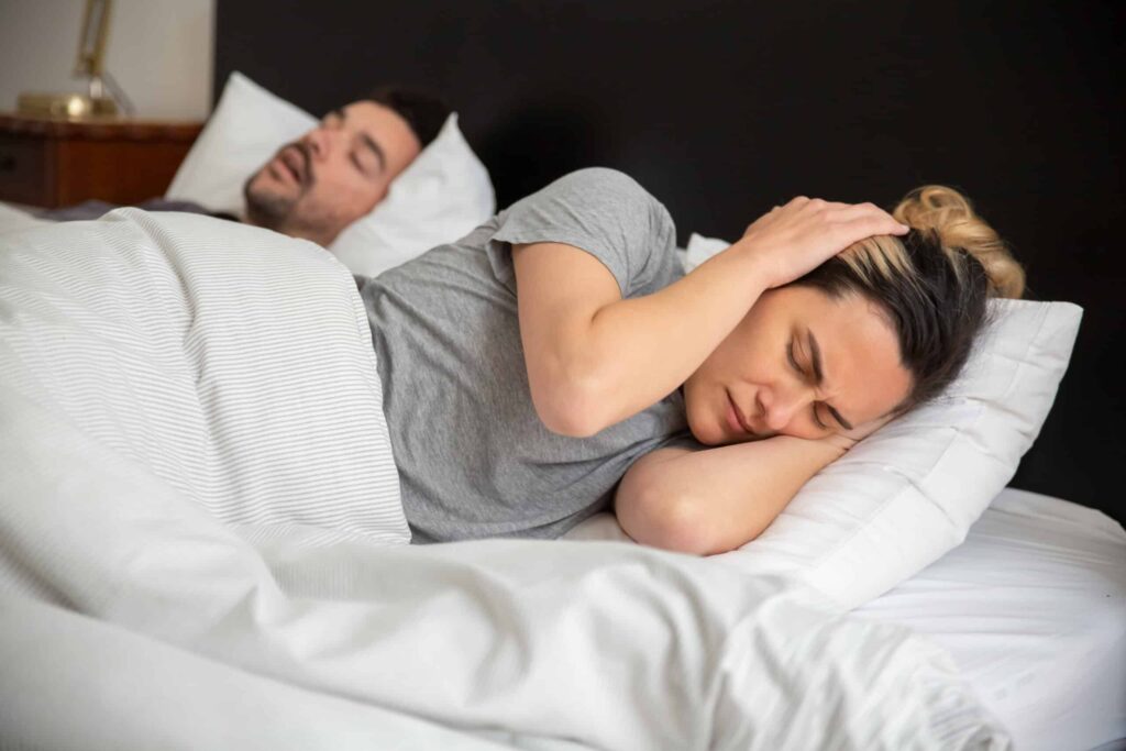 Woman in gray shirt lying on bed