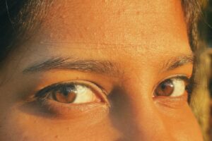 A close-up image highlighting expressive brown eyes with a warm sunlight glow.