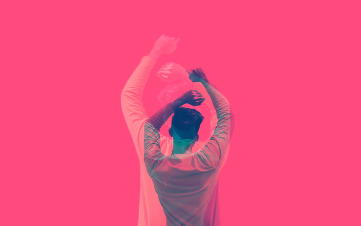 Artistic silhouette of a man dancing with a blurred effect against a pink background.