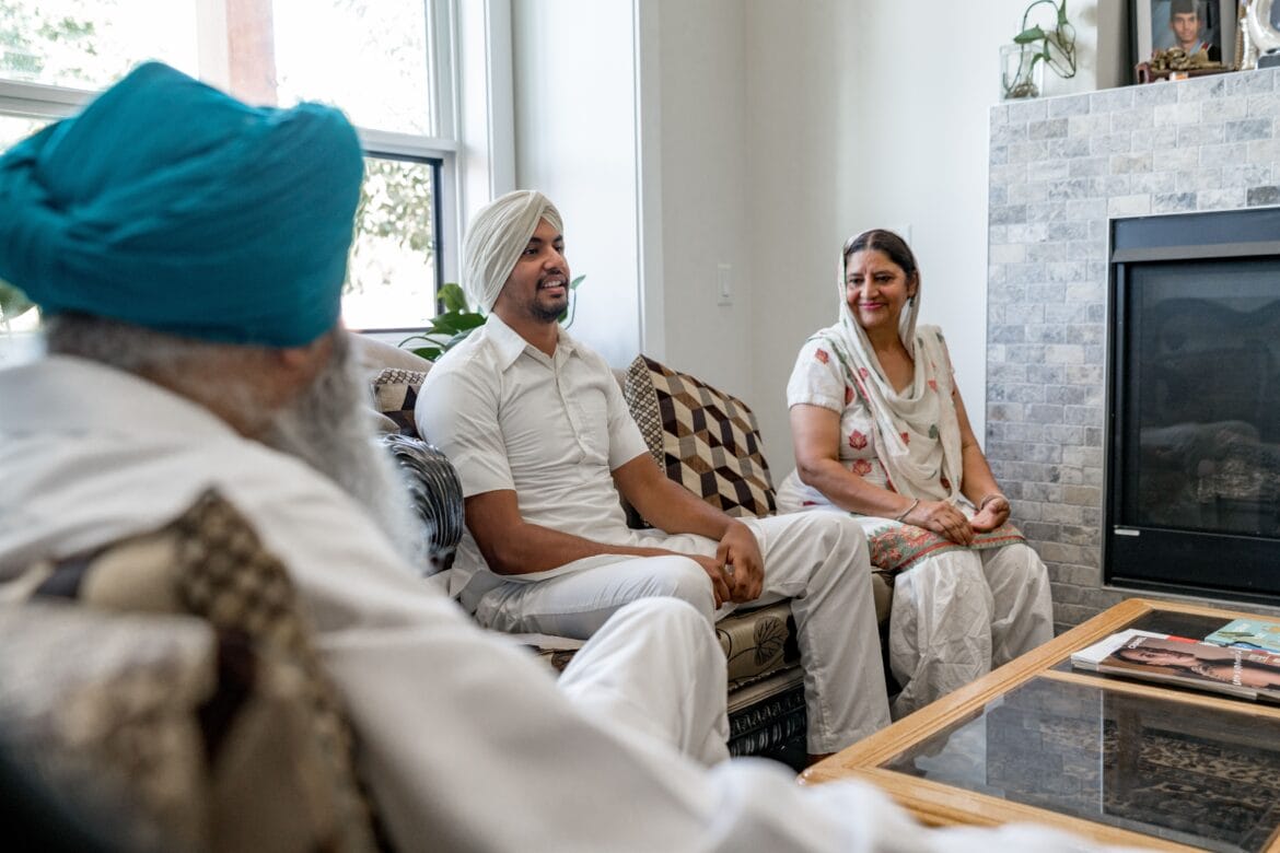 Family members seated together in a bright living room during a conversation.