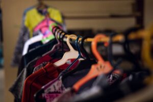 Colorful shirts and garments hang closely together on assorted hangers